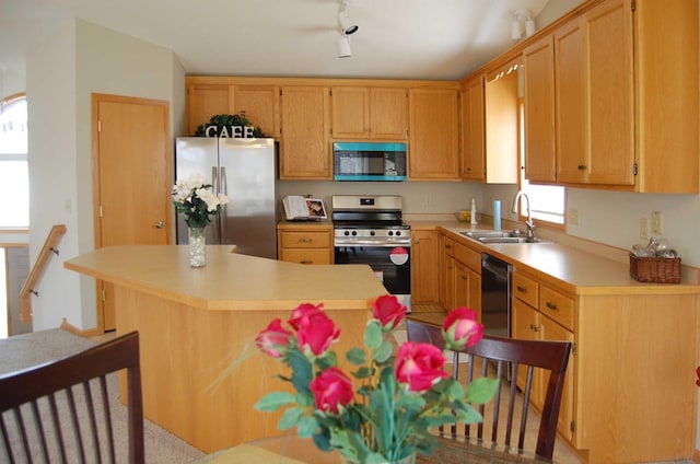 kitchen with a sink, stainless steel appliances, a center island, and light countertops