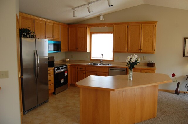 kitchen with lofted ceiling, light countertops, appliances with stainless steel finishes, and a sink