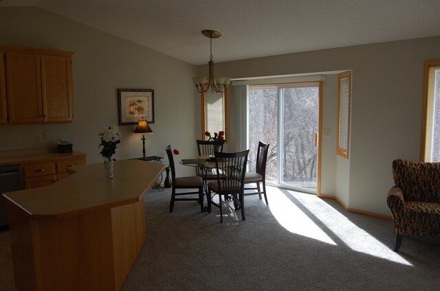 carpeted dining space with a chandelier, baseboards, and vaulted ceiling