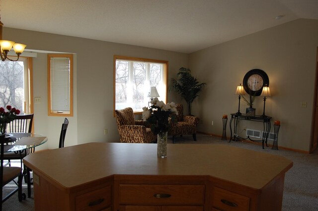 kitchen with lofted ceiling, carpet floors, light countertops, baseboards, and a chandelier