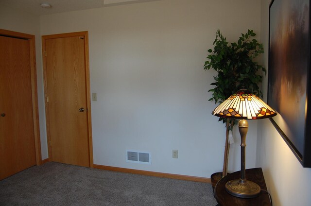 interior space featuring visible vents, carpet flooring, and baseboards