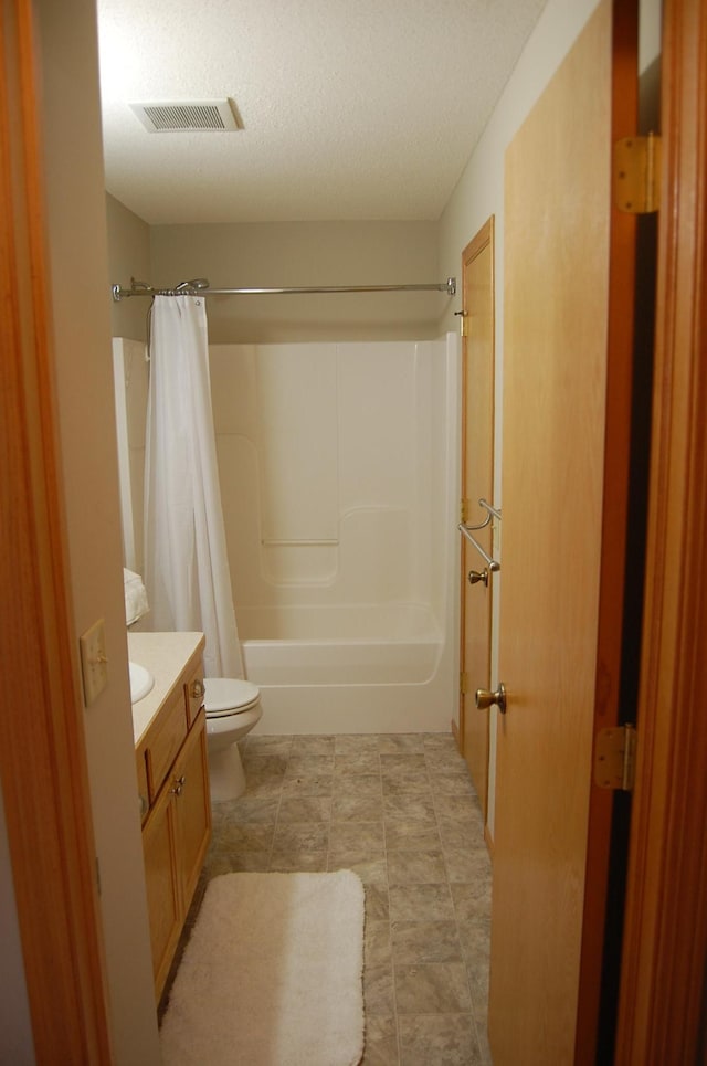 bathroom featuring vanity, shower / bathtub combination with curtain, visible vents, a textured ceiling, and toilet