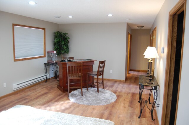 dining space featuring baseboards, light wood finished floors, a baseboard radiator, recessed lighting, and a bar