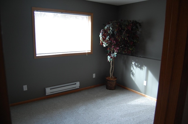 carpeted empty room featuring a baseboard radiator and baseboards