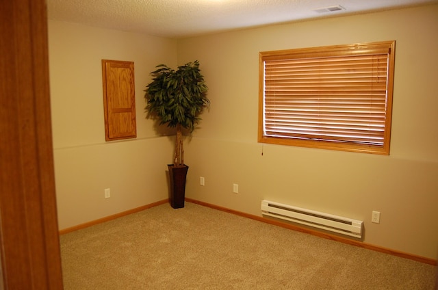 carpeted empty room with visible vents, baseboards, baseboard heating, and a textured ceiling