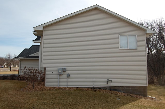 view of property exterior with a yard and a shingled roof