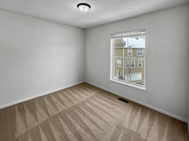 carpeted empty room with visible vents and baseboards