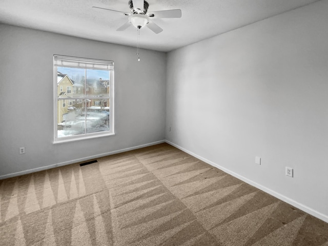 unfurnished room with visible vents, baseboards, ceiling fan, and carpet flooring