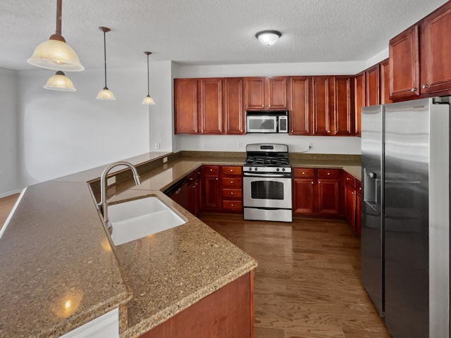 kitchen featuring dark wood-style floors, a sink, stainless steel appliances, a textured ceiling, and reddish brown cabinets