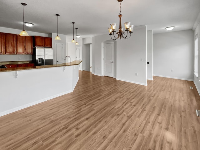 kitchen featuring a breakfast bar, dark countertops, open floor plan, and stainless steel fridge