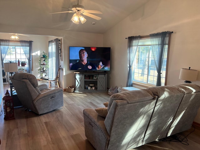 living room with a ceiling fan, lofted ceiling, and wood finished floors