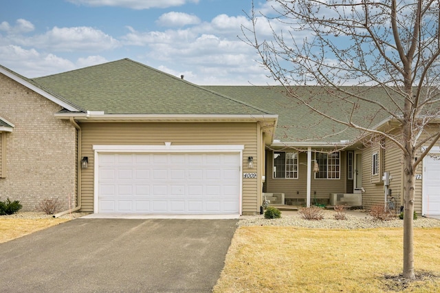 single story home featuring a garage, driveway, and roof with shingles