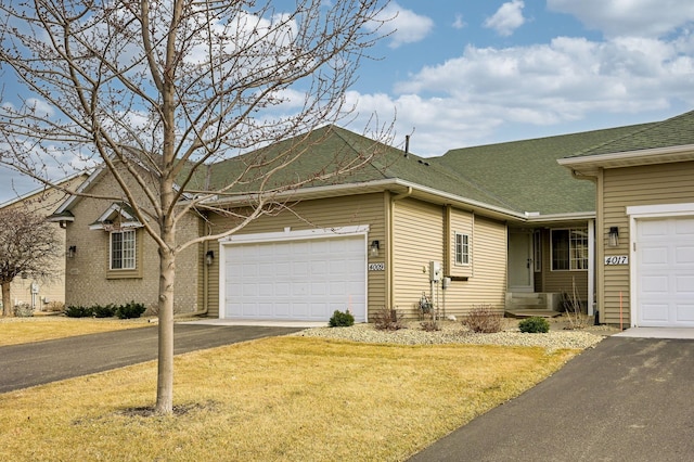 single story home featuring a garage, a front lawn, driveway, and a shingled roof