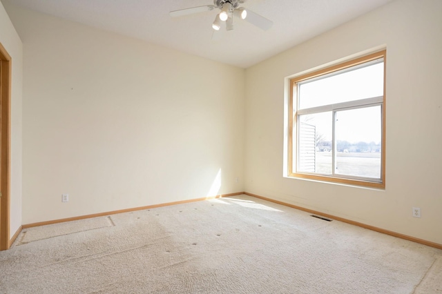 spare room with visible vents, baseboards, and a ceiling fan