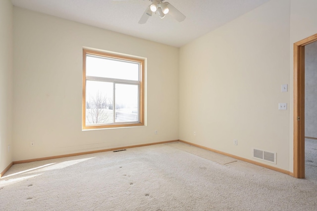 spare room with visible vents, baseboards, a ceiling fan, and carpet flooring