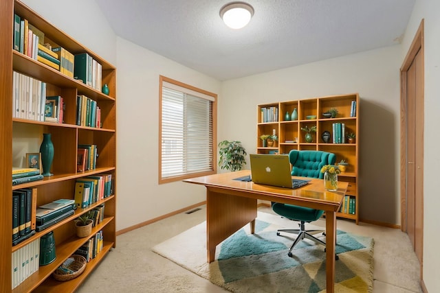 office featuring visible vents, a textured ceiling, baseboards, and carpet floors