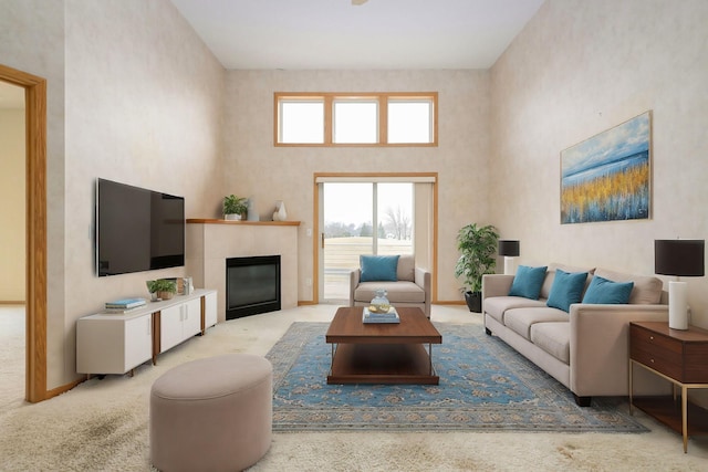 carpeted living room with baseboards, a high ceiling, and a fireplace