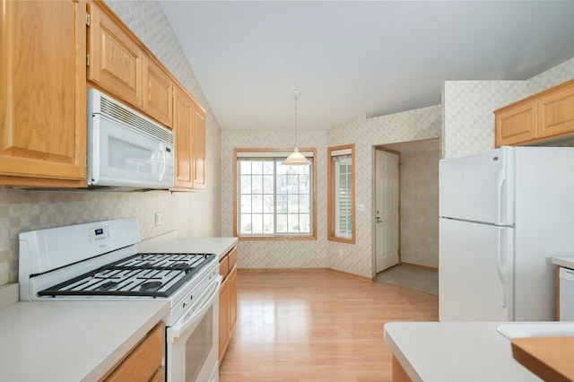 kitchen with white appliances, light wood-style floors, light countertops, and wallpapered walls