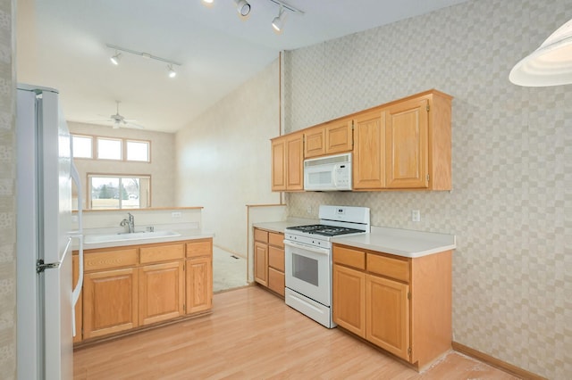 kitchen featuring wallpapered walls, ceiling fan, light countertops, white appliances, and a sink