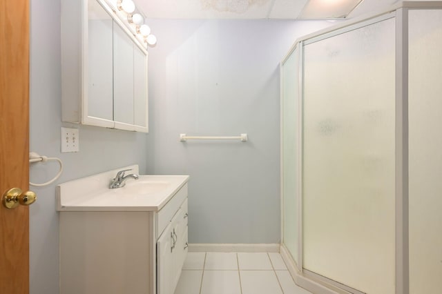 bathroom with tile patterned flooring, a stall shower, vanity, and baseboards