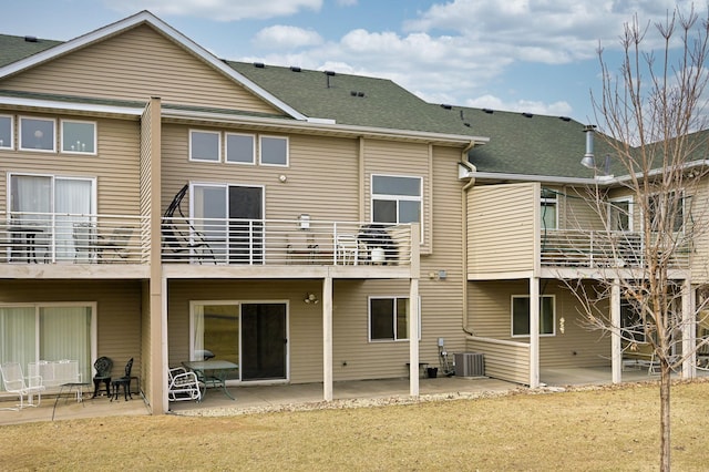 rear view of property featuring a patio, roof with shingles, and central AC unit