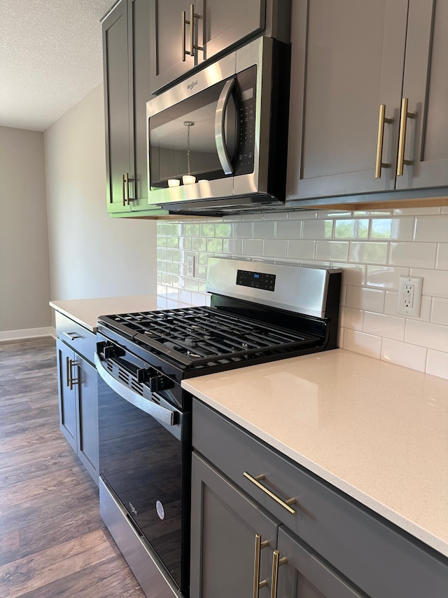 7856 Martin Ave NE, Otsego, MN 55330 - kitchen featuring stainless steel appliances, wood finished floors, gray cabinets, decorative backsplash, and light countertops