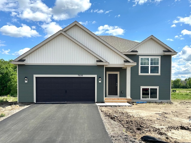 7856 Martin Ave NE, Otsego, MN 55330 - view of front of home with board and batten siding, a garage, asphalt driveway, and a shingled roof