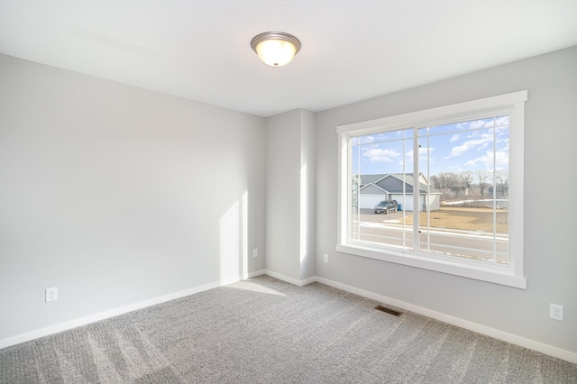 spare room with baseboards, visible vents, and carpet floors