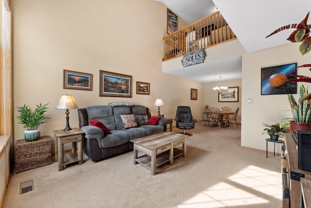 carpeted living area featuring a high ceiling, a notable chandelier, baseboards, and visible vents