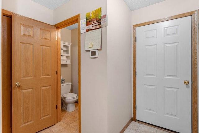 bathroom featuring tile patterned floors, toilet, and baseboards