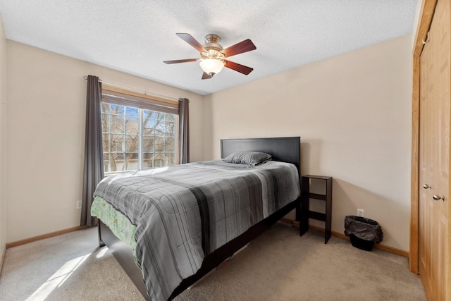 bedroom with carpet flooring, a textured ceiling, baseboards, and a ceiling fan