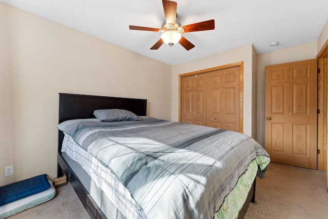 bedroom featuring a ceiling fan, a closet, and light carpet