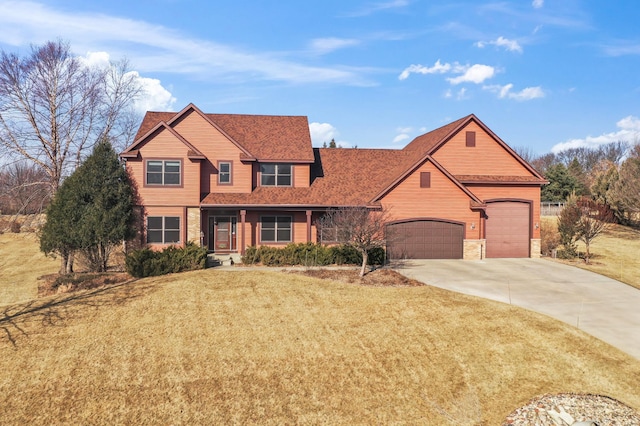 view of front of property featuring stone siding, a garage, driveway, and a front lawn