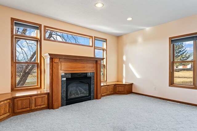 unfurnished living room with visible vents, light carpet, recessed lighting, a fireplace, and baseboards