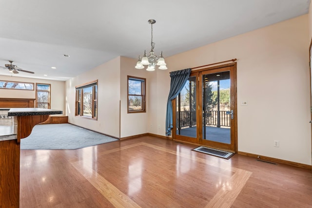 interior space featuring baseboards, plenty of natural light, and light wood finished floors