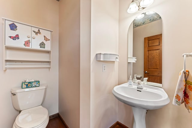 bathroom with baseboards and toilet