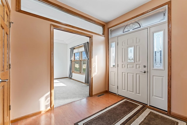 entryway with light wood-type flooring, baseboards, and visible vents