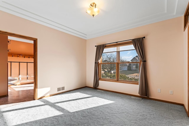 empty room featuring visible vents, carpet floors, and baseboards