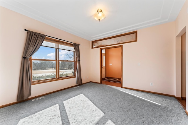 carpeted empty room with visible vents and baseboards