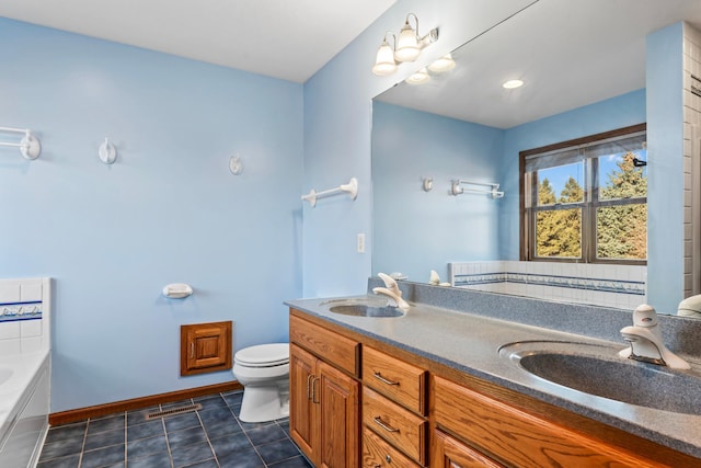 full bath featuring tile patterned floors, toilet, a garden tub, and a sink