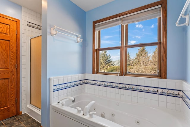 full bath with tile patterned floors, a tub with jets, and a shower stall