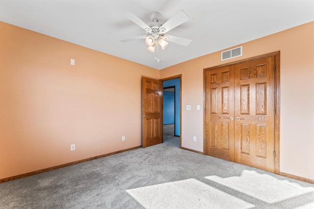 unfurnished bedroom with visible vents, a closet, carpet, baseboards, and ceiling fan