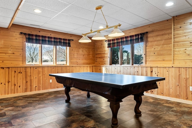 recreation room with recessed lighting, a drop ceiling, baseboards, and wood walls