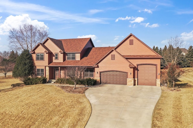 view of front of home featuring concrete driveway, stone siding, a garage, and a front yard