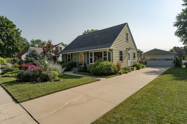 view of front of house with a detached garage, an outbuilding, roof with shingles, and a front lawn