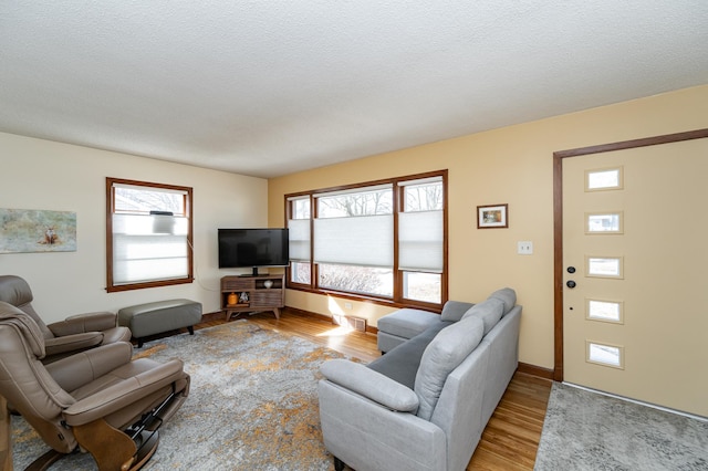 living room featuring plenty of natural light, a textured ceiling, and wood finished floors