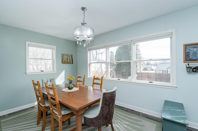 dining space with a notable chandelier, a healthy amount of sunlight, and baseboards