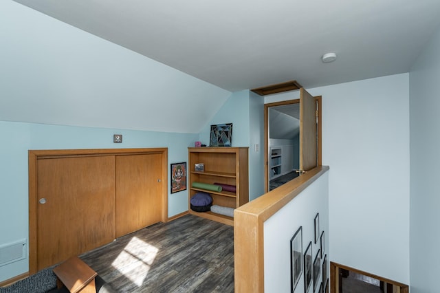 interior space featuring visible vents, dark wood-style floors, and vaulted ceiling