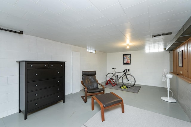 sitting room featuring concrete block wall and visible vents