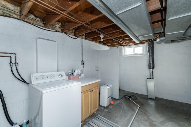 clothes washing area featuring washer / clothes dryer and cabinet space